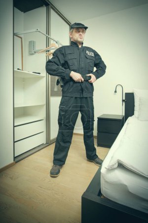 Photo for Older slim city police officer dressing up in bedroom for service - Royalty Free Image