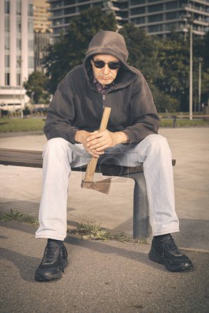 Foto de Hombre mayor agresivo con hacha bajo la influencia de drogas en el parque - Imagen libre de derechos
