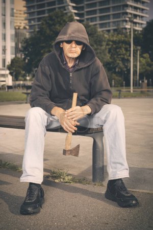 Téléchargez les photos : Agressif homme âgé avec hache sous l'influence de la drogue dans le parc - en image libre de droit