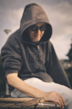 Photo for Aggressive older man under the influence of drugs in sunny city park - Royalty Free Image