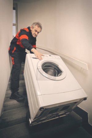 Foto de Hombre mayor en general la máquina de lavado en movimiento en el carro en el edificio - Imagen libre de derechos