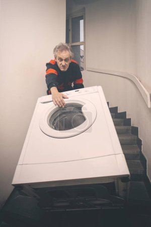 Téléchargez les photos : Homme plus âgé dans la machine à laver mobile globale sur le chariot dans la construction - en image libre de droit