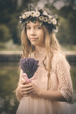 Photo for Nice young lady posing in pond water in apparel with lavender bouquet - Royalty Free Image