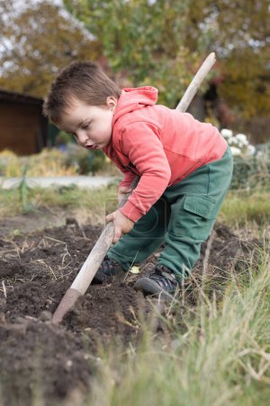 Foto de Niño jugando en el jardín como un artesano en buen día de otoño - Imagen libre de derechos