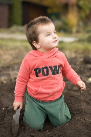 Foto de Niño jugando en el jardín con lombriz en la mano - Imagen libre de derechos