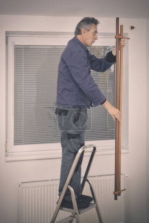 Foto de Hombre mayor desarmando consola de pared en apartamento vacío - Imagen libre de derechos