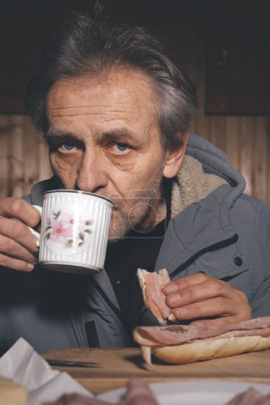 Foto de Ciudadano mayor pasar el tiempo de la noche y preparar la comida en su pequeño refugio cabaña - Imagen libre de derechos