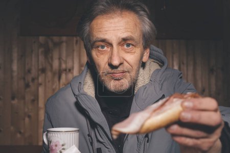 Foto de Ciudadano mayor pasar el tiempo de la noche y preparar la comida en su pequeño refugio cabaña - Imagen libre de derechos