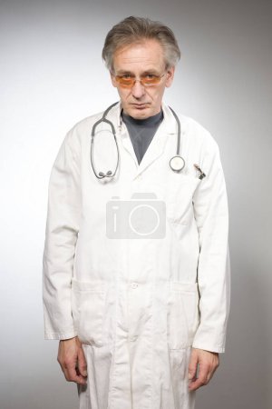 Foto de Médico practicante en bata médica tradicional retro aislado en el fondo - Imagen libre de derechos