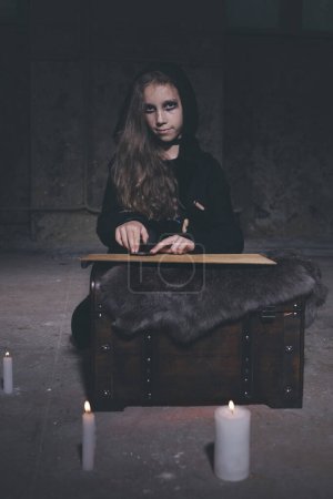 Foto de Chica joven en estilo halloween invocando fantasmas en casa vacía - Imagen libre de derechos