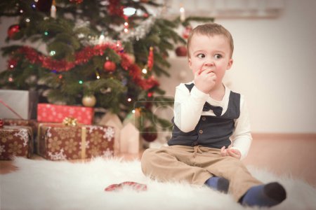 Foto de Niño pequeño en el momento del día de Navidad desempacar regalos cerca del árbol - Imagen libre de derechos