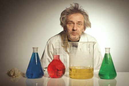 Téléchargez les photos : Un chimiste fou plus âgé prépare une expérience chimique avec des liquides - en image libre de droit