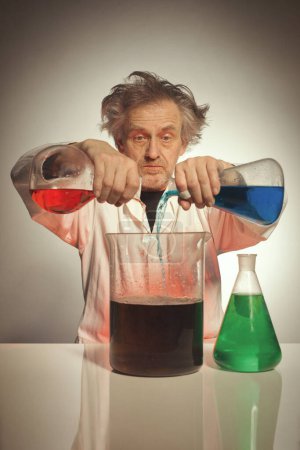 Foto de Mayor químico loco preparando un experimento químico con algunos líquidos - Imagen libre de derechos