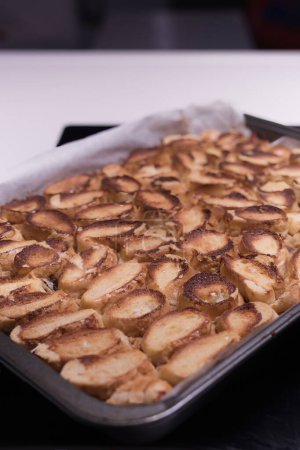 Téléchargez les photos : Cuisson du gâteau traditionnel aux pommes roulées aux noix, aux raisins secs et à la cannelle recouvert de neige blanche d'oeuf - en image libre de droit