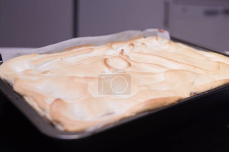 Foto de Horneado de torta de manzana tradicional con nueces, pasas y canela cubierta con nieve de clara de huevo - Imagen libre de derechos