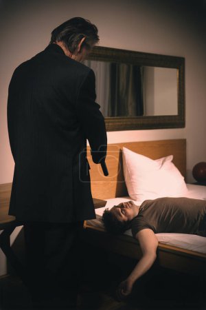 Photo for Old member of criminal  gang shooting victim in hotel room - Royalty Free Image