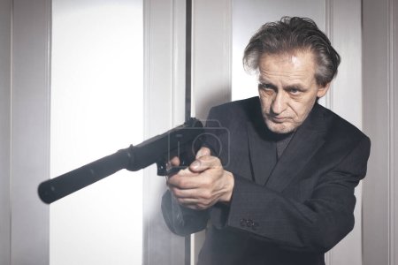 Antiguo miembro de la banda criminal en alerta listo para disparar en la habitación del hotel