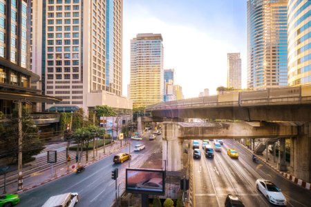 Foto de Día soleado en el centro de negocios de Bangkok, Tailandia. Modernos edificios de oficinas, condominios, centro de negocios, sistema de tránsito rápido BTS, rieles, transporte público, reflejos de vidrio, rascacielos, claro - Imagen libre de derechos