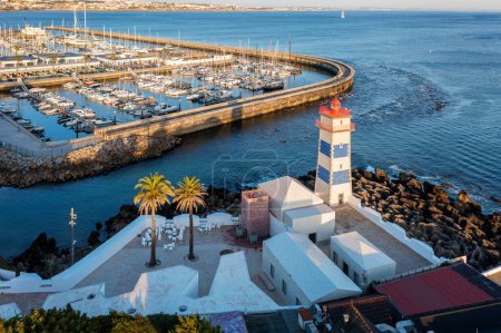 Panoramic view of Santa Marta lighthouse, marina of Cascais, Portugal before sunset on quiet sunny summer evening. Famous landmark by Cascais marina full of sailboats and yachts on Atlantic ocean