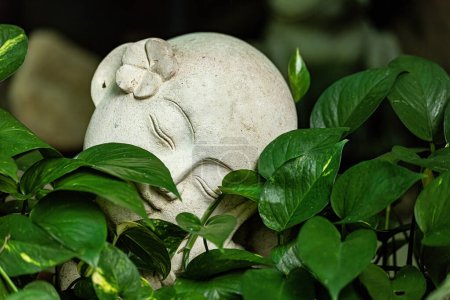 Tête de statue femme en marbre recouverte de feuilles de plantes vertes décoration design d'intérieur