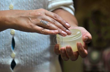 Téléchargez les photos : Mains de femme appliquant hydratant crème pour les mains sur - en image libre de droit