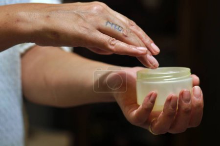 Téléchargez les photos : Mains de femme appliquant hydratant crème pour les mains sur - en image libre de droit