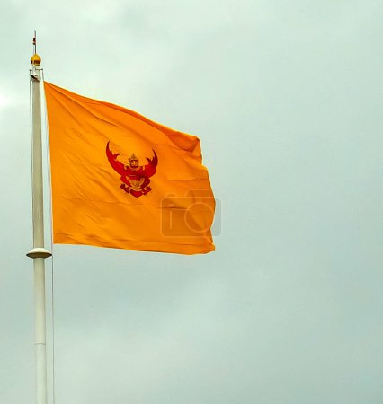 Foto de BANGKOK TAILANDIA-26 ABRIL 2022: La bandera amarilla de Garuda del Rey de Tailandia sobre un fondo de cielo oscuro.on BANGKOK TAILANDIA-26 ABRIL 2022 - Imagen libre de derechos
