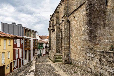 Photo for View of the church of Santa Maria del Azogue in Gothic style built in the second half of the XIV century, and stone cross views from the Plaza de Andrade in Betanzos, Galicia, Spain - Royalty Free Image