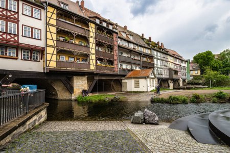 Foto de Erfurt, Alemania - 13 de mayo de 2023: Merchants Bridge, Kraemerbruecke in Erfurt, Alemania. Fue construido en 1325. El único puente al norte de los Alpes que está construido en su totalidad con casas - Imagen libre de derechos