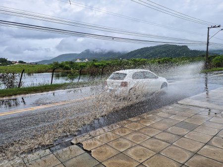 Téléchargez les photos : Campeche, Brésil - 20 déc. 2023 : Jour de pluie à Campeche Island, à Florianopolis, Brésil. Voitures sur route inondée - en image libre de droit
