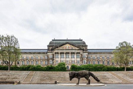 Téléchargez les photos : Dresde, Allemagne - 16 mai 2023 : Statue artistique vulpes gott devant le palais de la Cour Suprême de Terre à Dresde et la rive de l'Elbe, Allemagne - en image libre de droit