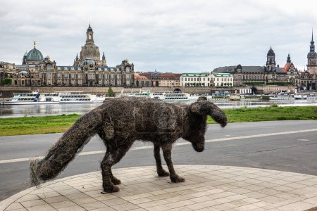 Téléchargez les photos : Dresde, Allemagne - 16 mai 2023 : Statue artistique vulpes gott devant le palais de la Cour Suprême de Terre à Dresde et la rive de l'Elbe, Allemagne - en image libre de droit