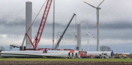 Téléchargez les photos : Société éolienne Vestas avec une grue rouge lors de la construction d'un parc éolien terrestre - en image libre de droit
