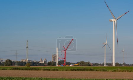Téléchargez les photos : Société éolienne Vestas avec une grue rouge lors de la construction d'un parc éolien terrestre - en image libre de droit