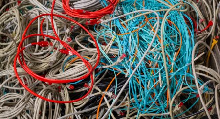 Foto de Cables de red de TI antiguos y cables de alimentación almacenados en una caja de celosía para su eliminación - Imagen libre de derechos