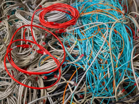 Foto de Cables de red de TI antiguos y cables de alimentación almacenados en una caja de celosía para su eliminación - Imagen libre de derechos