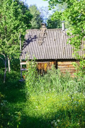 Bañera en un pueblo letón en verano. Casa de baño de madera en el campo.