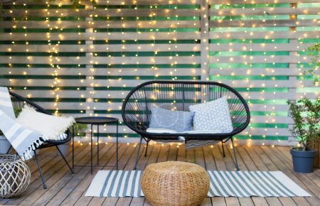 Photo for Lounge garden furniture at backyard. Black sofa and chair with pillows and blanket at the garden patio. - Royalty Free Image