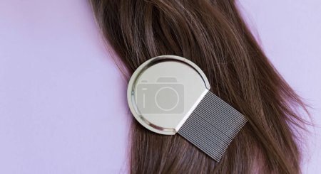 Photo for Lice comb and brunette hair on a violet background with copy space - Royalty Free Image