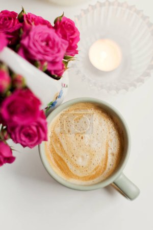 Photo for Cup with coffee, pink roses flowers and burning candles on a white background, copy space - Royalty Free Image