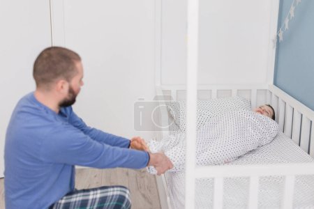 Dad tickles son in nursery after waking up