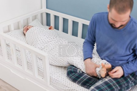 Dad tickles son in nursery after waking up