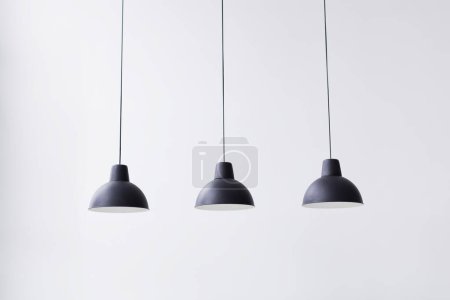 Lampe suspendue en métal noir sur fond blanc