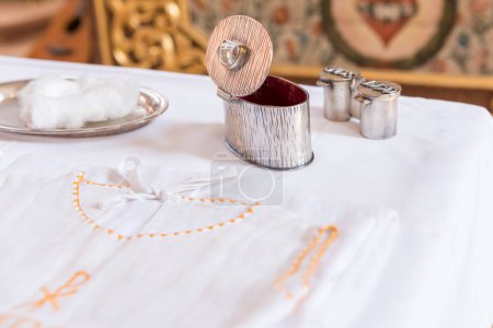 Foto de Chrisam oil in a vessel and holy water in a bowl. Preparation for the sacrament baptism - Imagen libre de derechos