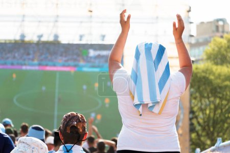 Téléchargez les photos : Fan argentin avec les bras levés et la tête couverte de maillot de l "équipe nationale acclame son équipe lors du match de championnat international au Qatar 2022. - en image libre de droit