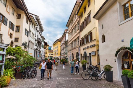 Téléchargez les photos : Bolzano, Italie - 23 août 2019 - Les gens marchent dans la rue étroite après la pluie - en image libre de droit
