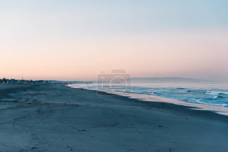 Foto de Calma amanecer en la playa con el cielo rosa en el fondo - Imagen libre de derechos