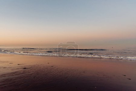 Photo for Calm sunrise on the beach with pink sky on the background - Royalty Free Image
