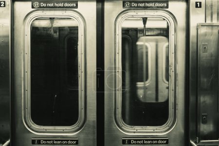 New Yorker U-Bahn-Türen und ein fahrender Zug im Hintergrund