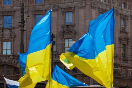Foto de Bandera con colores a rayas amarillas y azules de Ucrania ondeando en el viento con un cielo azul y sol. - Imagen libre de derechos